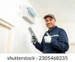 Small photo of Electrician man in uniform using tablet for maintenance or fixing switches sockets circuit breaker electrical system. Technician fixing an electric fuse at home. Home service concept.