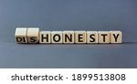 Small photo of Honesty or dishonesty symbol. Turned cube and changed the word 'dishonesty' to 'honesty'. Beautiful grey background. Business and honesty or dishonesty concept. Copy space.