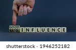 Small photo of Good or bad influence symbol. Businessman turns cubes and changes words 'bad influence' to 'good influence'. Beautiful grey background. Business, good or bad influence concept. Copy space.
