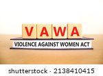 Small photo of VAWA violence against women act symbol. Concept words VAWA violence against women act on cubes. Beautiful white background. Business, motivational VAWA violence against women act concept.