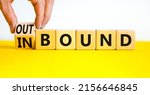 Small photo of Inbound or outbound symbol. Businessman turns wooden cubes and changes the concept word Outbound to Inbound. Beautiful yellow table white background. Business inbound or outbound concept. Copy space.