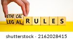 Small photo of Ethical or legal rules symbol. Businessman turns wooden cubes and changes words 'ethical rules' to 'legal rules' on a beautiful white background. Business, ethical or legal rules concept. Copy space.