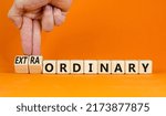 Small photo of Ordinary or extraordinary symbol. Businessman turnes wooden cubes and changes words 'Ordinary extraordinary'. Beautiful orange background. Business, Copy space.