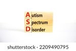 Small photo of ASD, autism spectrum disorder symbol. Wooden blocks with words 'ASD, autism spectrum disorder'. Beautiful white background. Medical and ASD, autism spectrum disorder concept. Copy space.