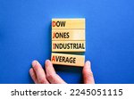 Small photo of DJIA Dow Jones industrial average symbol. Concept words DJIA Dow Jones industrial average on wooden block on beautiful blue background. Business DJIA Dow Jones industrial average concept. Copy space