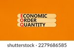 Small photo of EOQ economic order quantity symbol. Concept words EOQ economic order quantity on wooden stick on a beautiful orange table orange background. Business EOQ economic order quantity concept. Copy space.