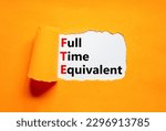 Small photo of FTE Full time equivalent symbol. Concept words FTE Full time equivalent on white paper. Beautiful orange table orange background. Business and FTE Full time equivalent concept. Copy space.