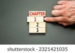 Small photo of Time to chapter 1 symbol. Concept word Chapter 1 2 3 on wooden block. Businessman hand. Beautiful grey table grey background. Business planning and time to chapter 1 concept. Copy space.