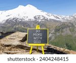 Small photo of Do more with less symbol. Concept word Do more with less on beautiful black chalk blackboard. Beautiful mountain Elbrus background. Business do more with less concept. Copy space.