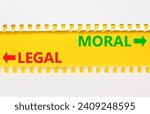 Small photo of Moral or legal symbol. Concept word Moral or Legal on beautiful yellow paper. Beautiful white paper background. Business and moral or legal concept. Copy space.