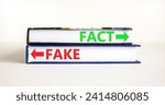Small photo of Fact or fake symbol. Concept word Fake and Fact on beautiful books. Beautiful white table white background. Business and fact or fake concept. Copy space.