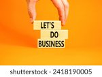 Small photo of let is do business symbol. Concept words let is do business on beautiful wooden blocks. Beautiful orange table orange background. Businessman hand. let is do business concept. Copy space.