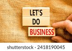 Small photo of let is do business symbol. Concept words let is do business on beautiful wooden blocks. Beautiful canvas table canvas background. Businessman hand. let is do business concept. Copy space.
