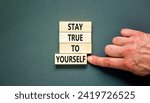 Small photo of Stay true to yourself symbol. Concept word Stay true to yourself on beautiful wooden block. Beautiful grey table grey background. Businessman hand. Business stay true to yourself concept. Copy space.