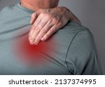 Man suffering from shoulder blade pain. Trigger point. Hand holding shoulder with red point closeup. Back injury. Health care, joint diseases concept. High quality photo