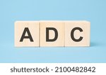 Small photo of ADC word written on wooden cubes with copy space