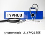 Small photo of typhus word on file folder and stethoscope on white background