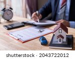 Man signing a contract when buying a new house and car Purchase agreement for ours with model home, Man sign a home insurance policy on home loans, Businessman signing contract insurance