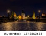 
old paved sidewalk with paving stones in memory of Charles Bridge from the 14th century in the center of Prague and in the background the old bridge tower at night in the Czech Republic