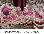 Small photo of heel on glass on women bag with necklaces, bracelets, lipsticks on tigerish base