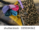 Small photo of flower of linen with pink and blue petals with notepad with tigerish cover and violet handle of pencil on it on yellow wallet