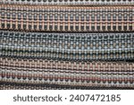Small photo of Braid with ornament.Decorative braid - woven multi-colored threads. Braid is a narrow woven or braided strip or cord, usually having only 1 system of obliquely woven threads.