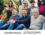 Group of multi generational people having fun together outdoor - Multiracial friends enjoy day at city park