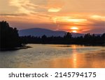 Sunset over the river in the forest. Sundown on mountain hill