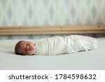 Small photo of Newborn baby in a diaper sleeps on the bed. Childhood, infancy, parenthood, motherhood concept