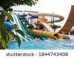 Have fun riding slides in an aquapark. Summer vacation entertainment ideas. Colorful slide variety and turquoise swimming pool at a hotel. Water reflection in empty aqua park during pandemic isolation