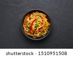 Vegetarian Schezwan Noodles or Vegetable Hakka Noodles or Chow Mein in black bowl at dark background. Schezwan Noodles is indo-chinese cuisine hot dish with udon noodles, vegetables and chilli sauce