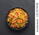 Small photo of Veg Schezwan Fried Rice in black bowl at dark slate background. Vegetarian Szechuan Rice is indo-chinese cuisine dish with bell peppers, green beans, carrot. Top view