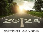 2024 New Year, team motivation, encourage, collaboration concept. Teamwork, empowerment for achieving success. 2024 written and teamwork icons on the road in the middle of asphalt road with at sunset.