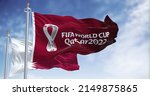Small photo of Doha, Qatar, January 2022: Flags Qatar 2022 World Cup logo waving among Qatar national flag in the wind. The event is scheduled in Qatar from 21 November to 18 December 2022