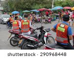 Small photo of Bangkok, Thailand - May 2, 2015: Motorcycle Taxis with orange vests are waiting for customers at a market. Locals use the service when they need to get somewhere fast.