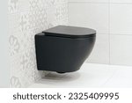 Black wall hung toilet in the bathroom. Wall-hung WC without flush rim - Dirt and germs hardly have a chance to take hold. Modern sanitary equipment.