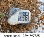 Small photo of Mysterious stone found in the forest. Magic square. Luoshu magic square. Recreational mathematics. Spell supposedly allows control river and protect themselves from floods.