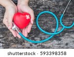 Small photo of Healthcare medical insurance business and world heart health day concept with red heart and bandage (band-aid) on woman's hands support with doctor's stethoscope