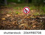 Small photo of A round sign prohibiting the use of an open fire in nature. Bonfires are prohibited. A flammable area of the forest. A fire-hazardous situation. A crossed out burning match.