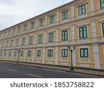 Small photo of Yellow building with vintage style concatenation green windows.