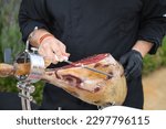 Small photo of Detail of an Iberian ham cut by a professional. Concept pork, food, ham, iberian, spain, denomination of origin.
