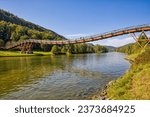 the famous pedestrian wooden bridge called tatzlwurm over the rhine-main-danube canal with hikers in sunlight and blue sky