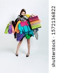 Small photo of Shopping like an issue. Woman addicted of sales. Overproduction and crazy demand. Female model wearing too much colorful clothes, need more. Fashion, style, black friday, sale, abusing purchases.
