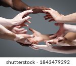 Small photo of Planet Earth. Hands of different people in touch isolated on grey studio background. Concept of relation, diversity, inclusion, community, togetherness. Weightless touching, creating one unit.