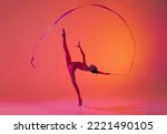 Beautiful and flexible graceful athlete rhythmic gymnastic artist dancing, doing stretch exercises isolated on colorful background in neon. Beauty, art, sport, competition, ad and hobbies concept