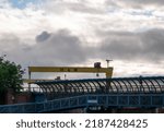 Small photo of Belfast, Northern Ireland - June 8 2022: Belfast cityscape with a view of a famous HW yellow crane and Titanic Museum