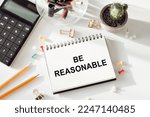 Be reasonable - text written on notebook on ofiice table