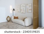 Small photo of a soft comfortable sofa with a floor lamp is an open-plan apartment in a modern style with light walls and wooden floors and a stylish golden partition
