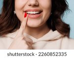 Small photo of Happy girl showing toothy smile, pointing finger at healthy white teeth. Clinic patient satisfied with dentist service, enamel cleaning, whitening, dental care, correction. Cropped shot, close up