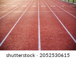 Athletic track in natural light with long numbered lanes to the horizon gives the feeling of preparedness focus and direction, with no people, and copy space